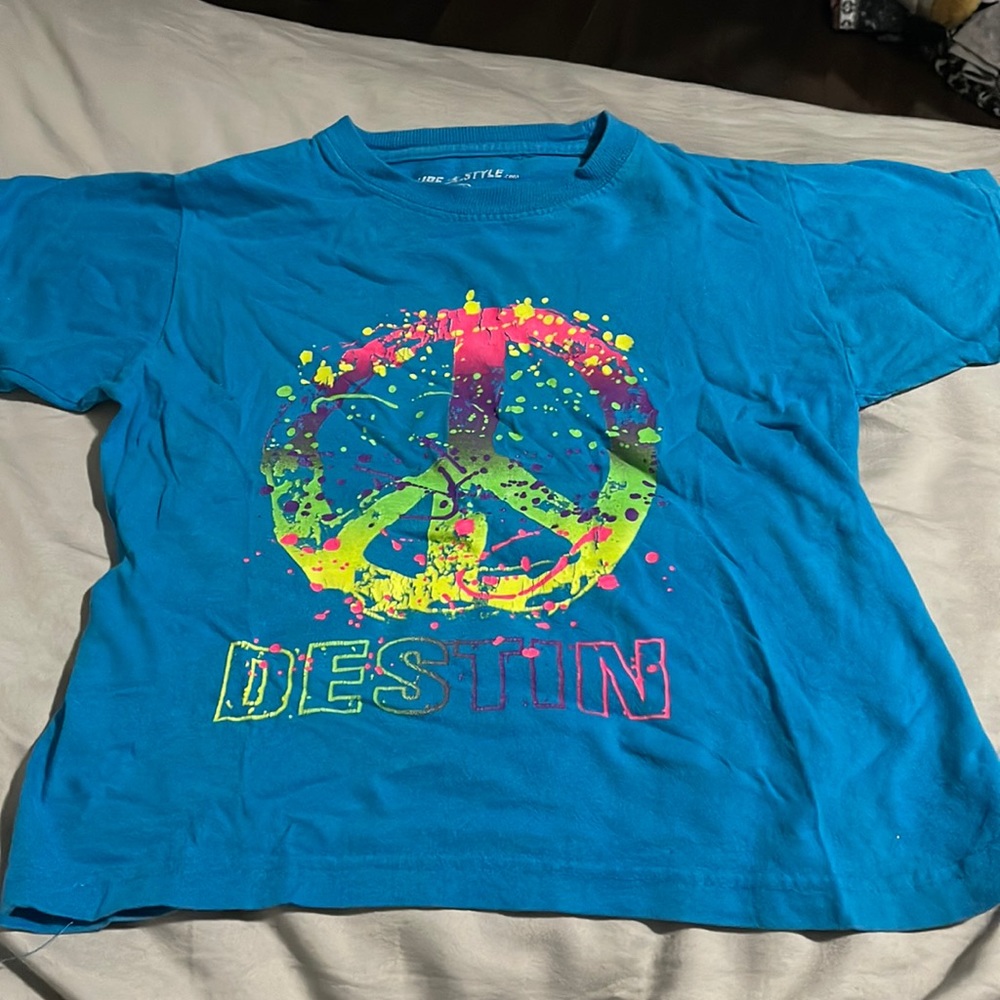 A blue surf style shirt with a peace sign symbol in size 6/8